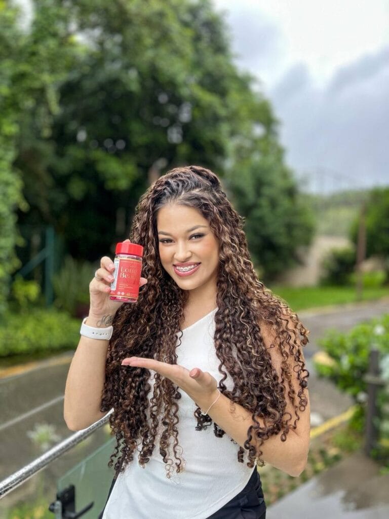 Mulher mostrando o pote do Suplemento Long Beauty